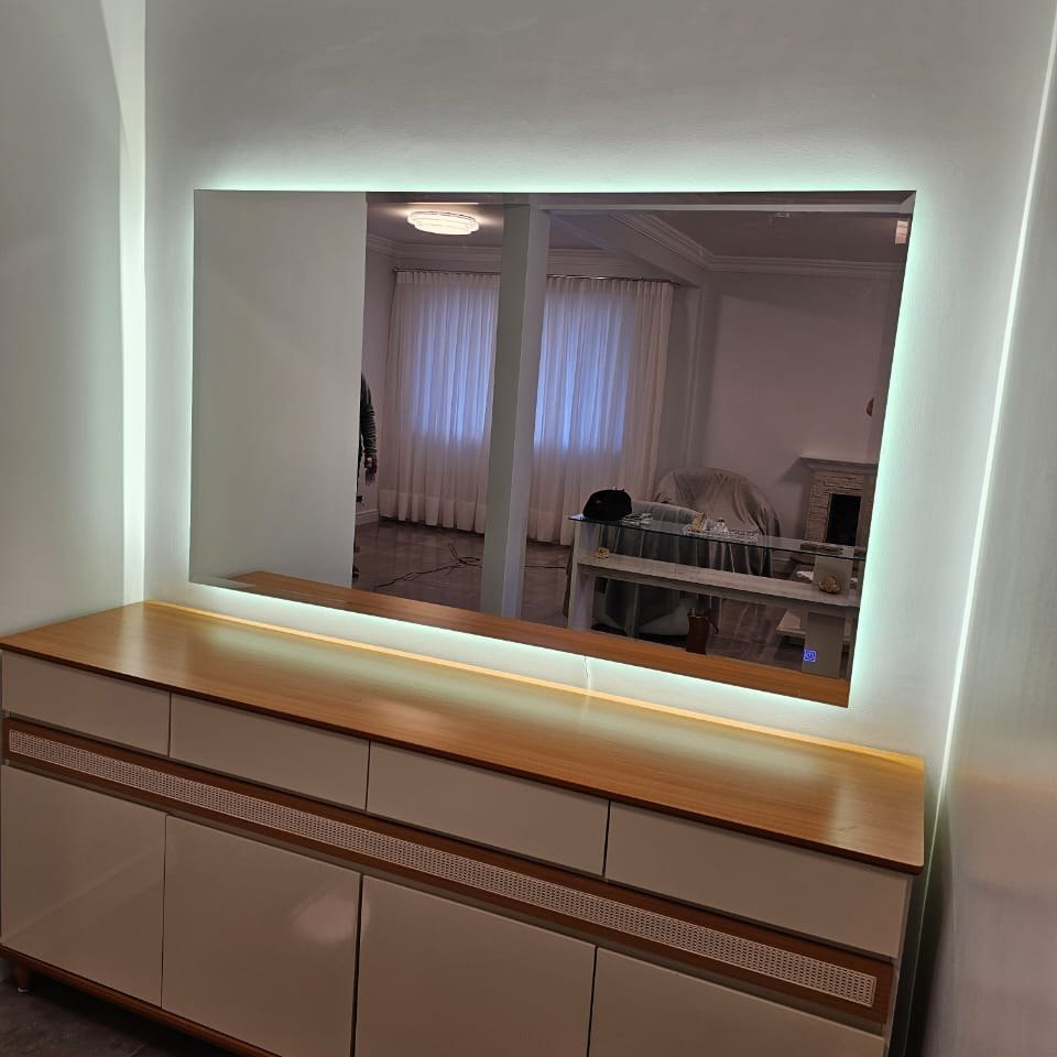 Espelho grande com LED sobre cômoda em quarto