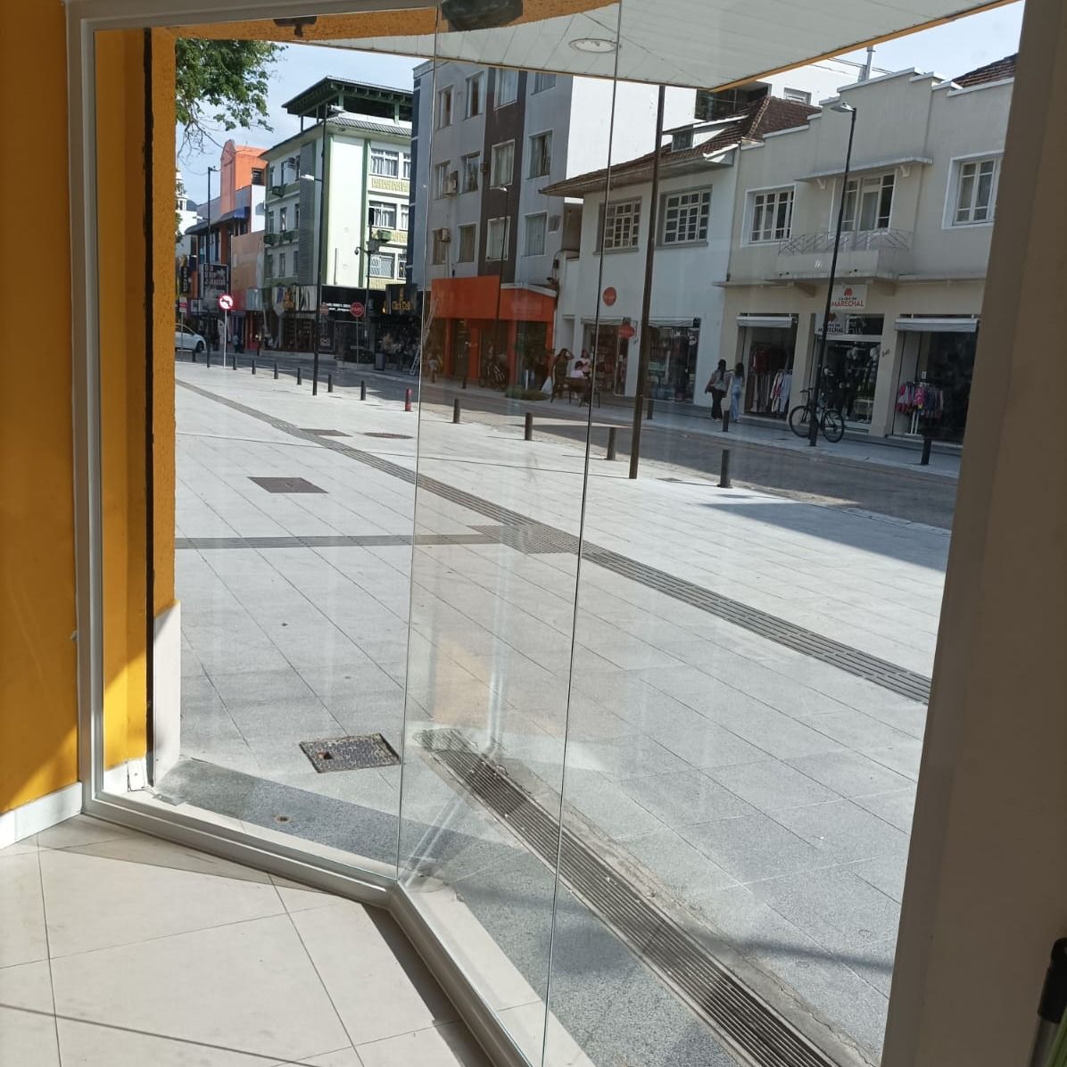 Porta de vidro temperado instalada em fachada comercial pela Vidraçaria Dinâmica
